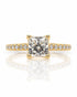 Yellow gold solitaire ring with princess-cut diamond in four-claw setting and pavé shoulders