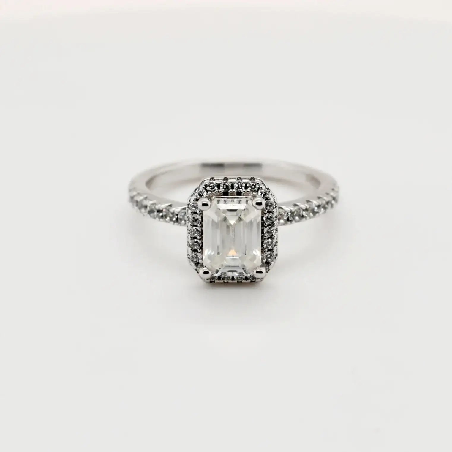 1.00ct emerald cut moissanite halo engagement ring in sterling silver with pavé band by Cassim & Co.