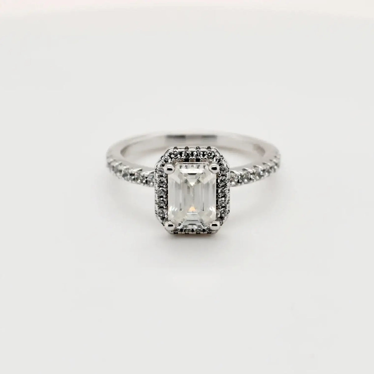 1.00ct emerald cut moissanite halo engagement ring in sterling silver with pavé band by Cassim & Co.