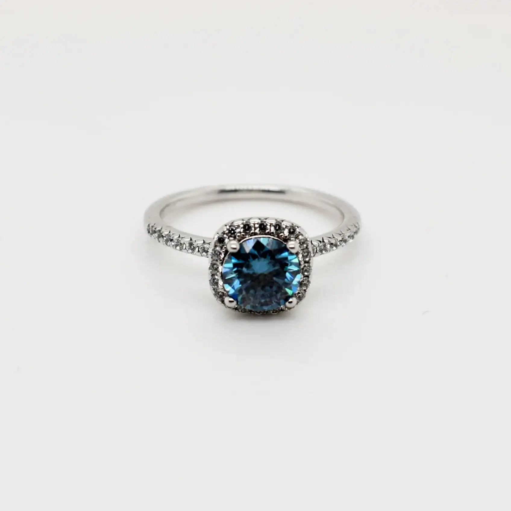 1ct blue cushion cut moissanite halo engagement ring in 9ct white gold with pavé band by Cassim & Co