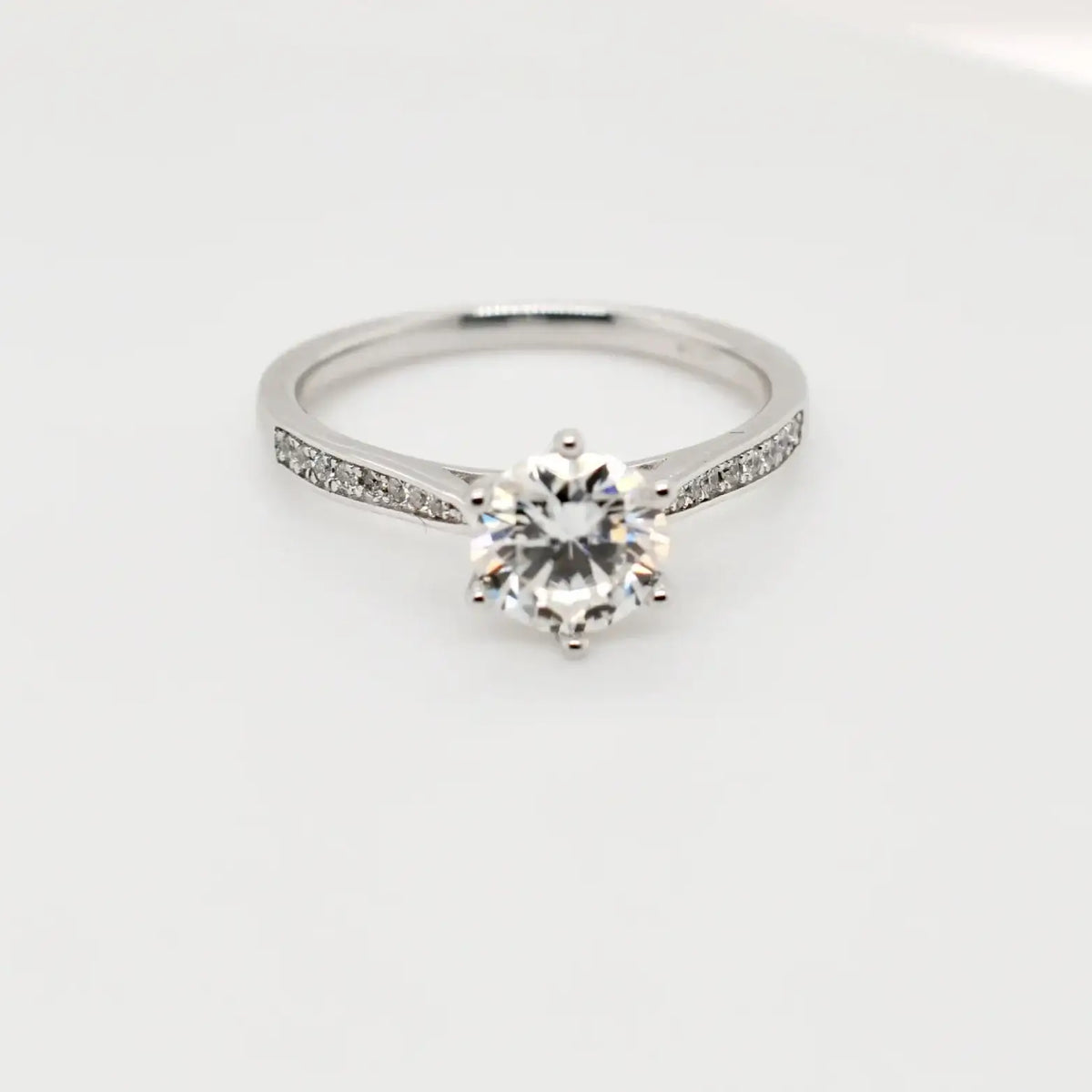 1.00ct round moissanite engagement ring in sterling silver with 6-claw setting and pavé shoulders, Cassim & Co
