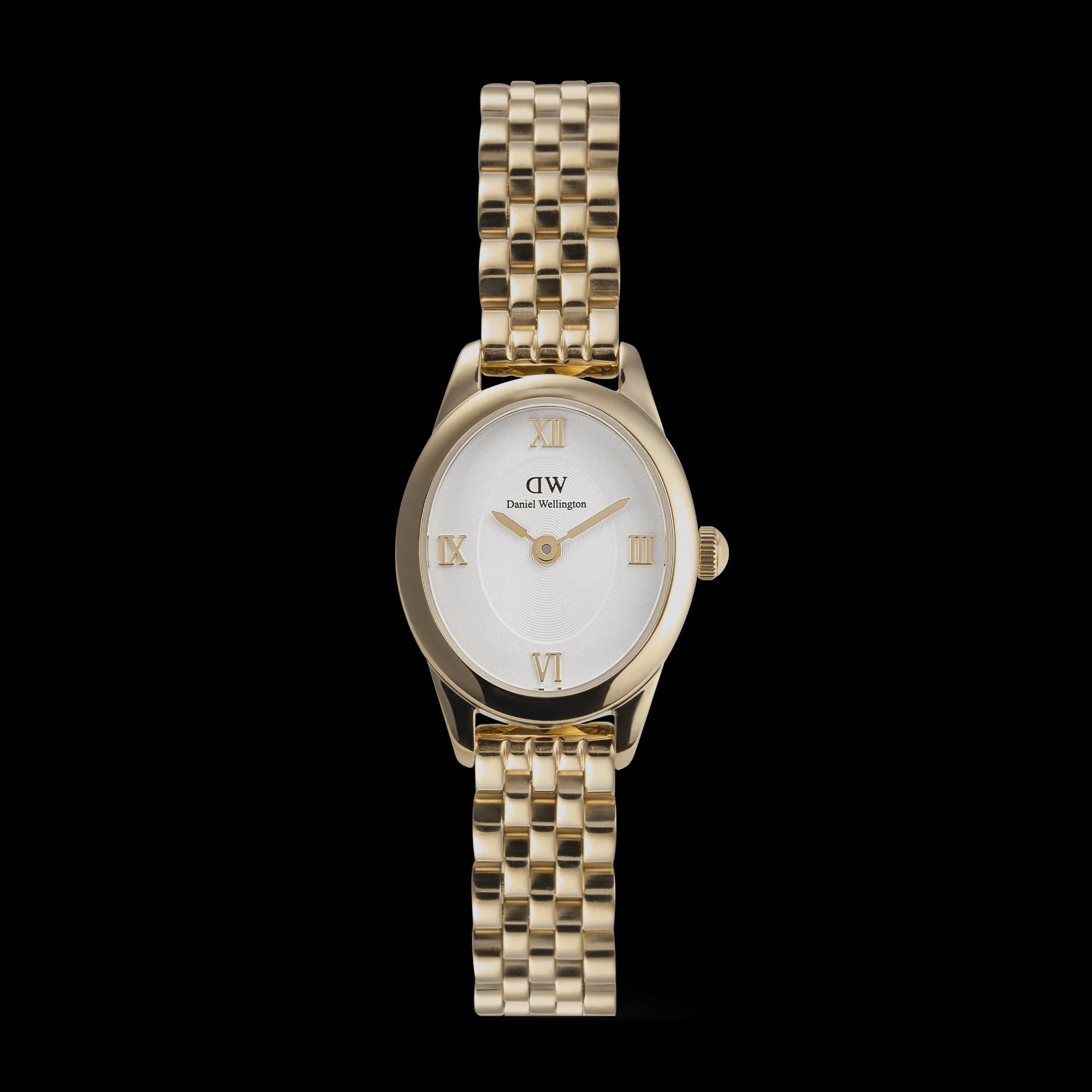 Daniel Wellington Petite ladies watch with oval gold-tone case, white Roman numeral dial and five-link gold-tone bracelet on black background