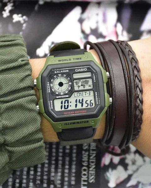Green Casio digital watch on a wrist with multiple bracelets against a blurred background