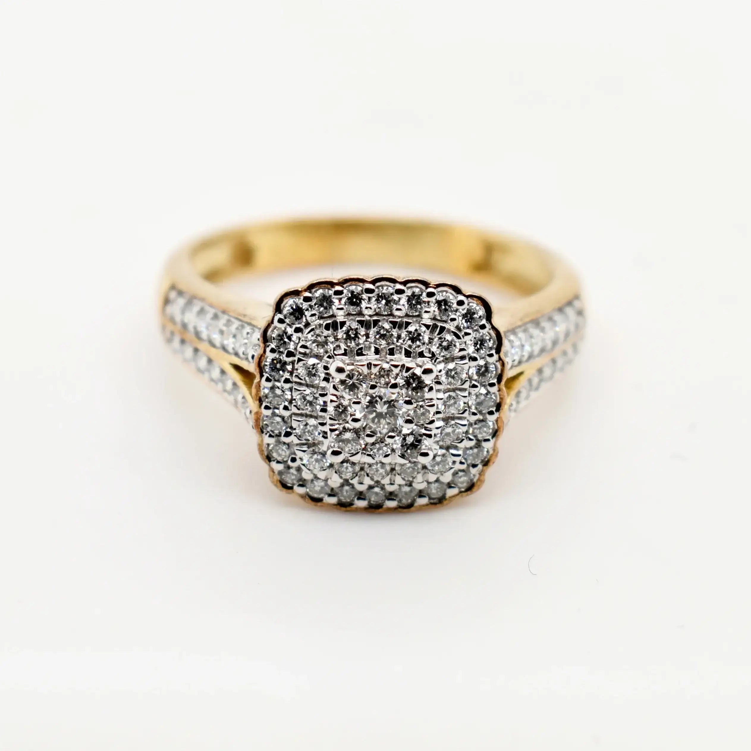 9ct yellow gold cushion cut diamond cluster engagement ring with double halo and pavé set shoulders on white background