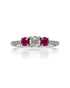 9ct white gold trilogy engagement ring with round diamond centre, ruby side stones and pavé diamond shoulders