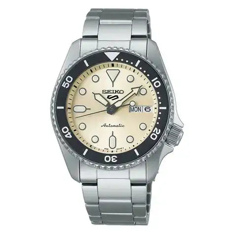 Seiko 5 Sports SRPK31K1 automatic dive watch with cream dial, black bezel, and stainless steel bracelet on white background