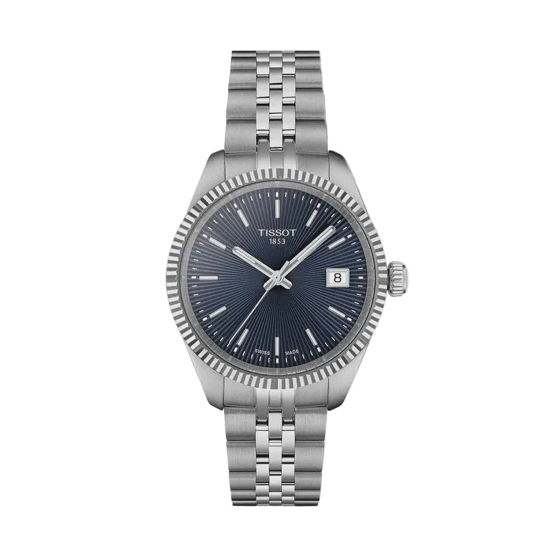 Tissot Ballade Swiss Quartz watch with sunburst blue dial, fluted stainless steel bezel, and three-link stainless steel bracelet on white background