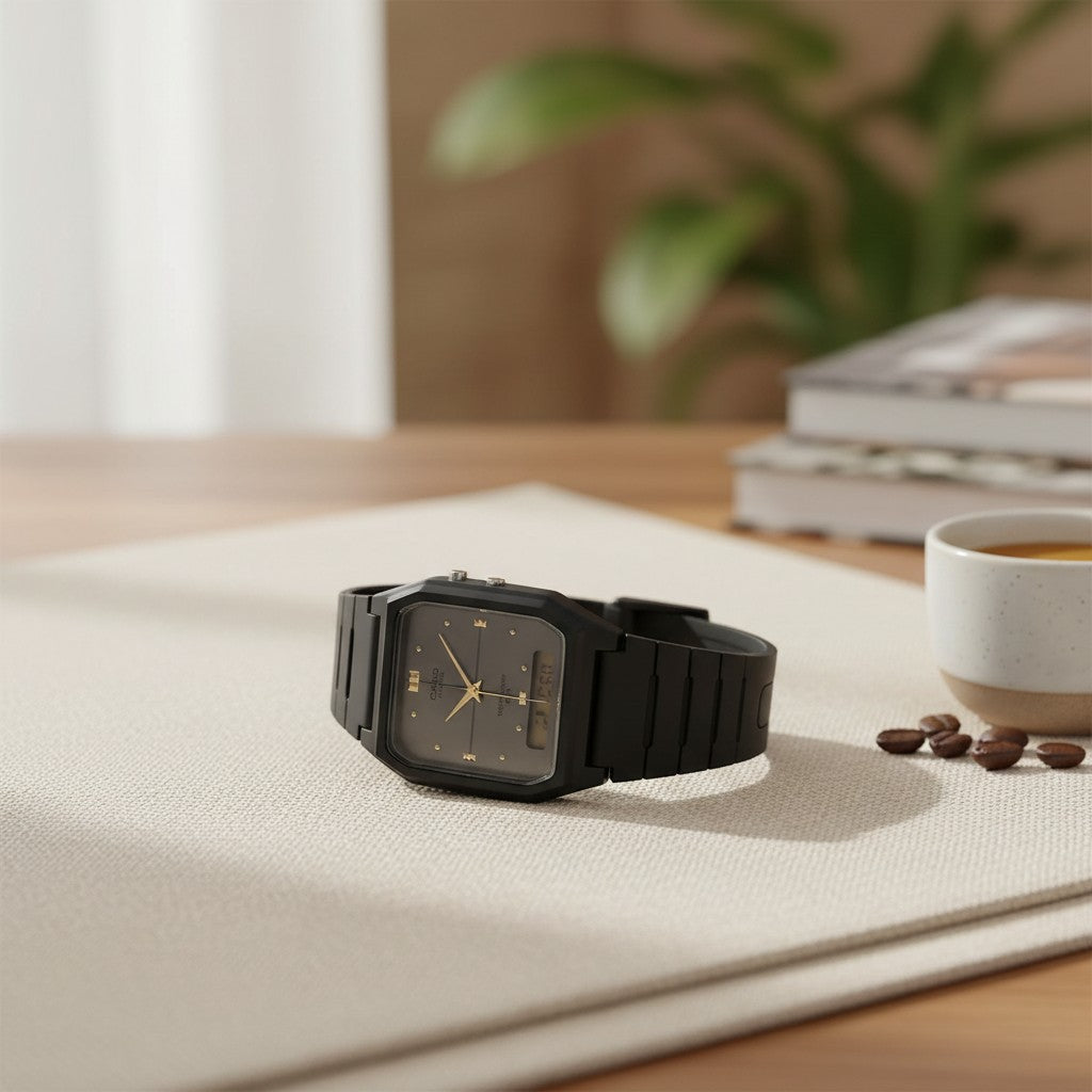 Cassims&Co. Casio ana-digi watch with a grey dial, gold indices, and black resin strap on a desk with coffee beans.