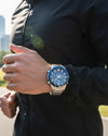 Cassims&Co. Casio Edifice Bluetooth chronograph watch with blue bezel and stainless steel band worn by a runner outdoors.