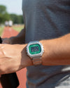 Cassims&Co. Casio Illuminator digital watch with a green dial and stainless steel bracelet worn on a runner's wrist.