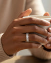 Cassims&Co. 9ct white gold eternity ring featuring nine emerald-cut lab grown diamonds on a woman's finger.