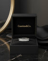 Cassims&Co. 9ct white gold eternity ring featuring nine emerald-cut lab grown diamonds in a black presentation box.