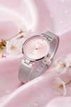 Cassims&Co. Obaku Diamant watch with a pink sunburst dial, diamond accent, and silver mesh strap on pink silk fabric.