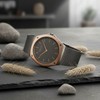 Cassims&Co. Obaku Lagen Granite watch with a grey mother-of-pearl dial, rose gold bezel, and black mesh bracelet.
