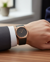 Cassims&Co. Obaku Lagen Granite watch with rose gold bezel and black mesh bracelet worn on a wrist