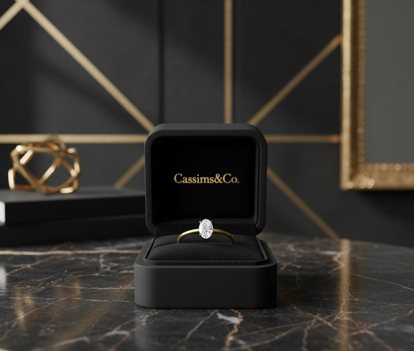 Cassims&Co. 9ct yellow gold engagement ring featuring a 0.50ct oval lab grown diamond in a black velvet ring box.