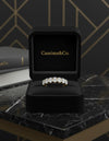 Cassims&Co. 9ct yellow gold seven-stone oval lab grown diamond ring displayed in a black velvet jewellery box.