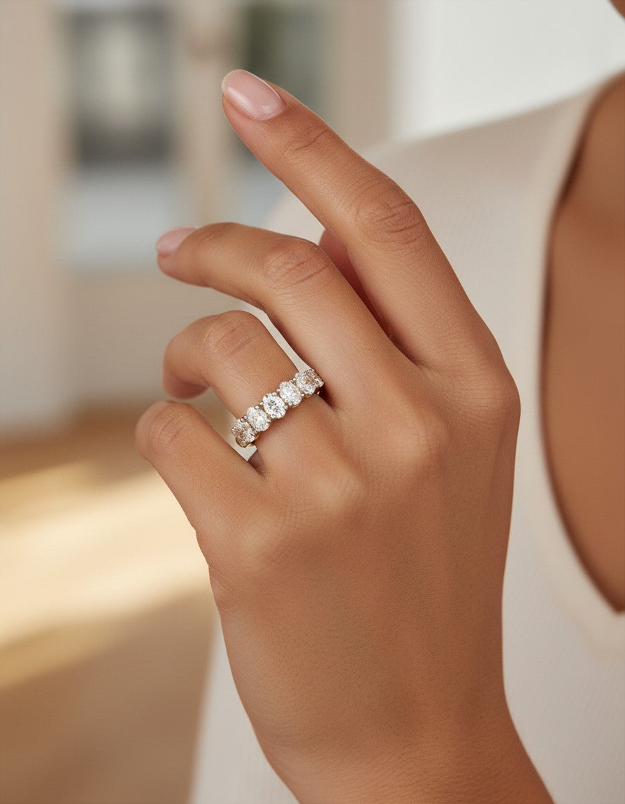 Cassims&Co. 9ct yellow gold seven-stone ring featuring 1.39ct oval lab grown diamonds on a woman's finger.