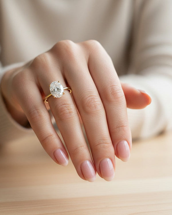 Cassims&Co. 9ct yellow gold ring featuring a 1.50ct oval lab grown diamond on a woman's finger.