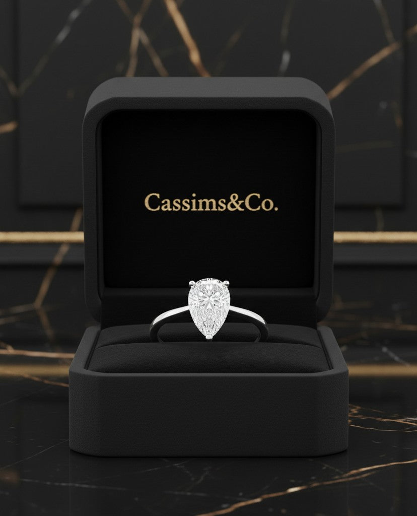 Cassims&Co. 1.58ct pear-shaped lab grown diamond solitaire engagement ring in 9ct white gold inside a black box.