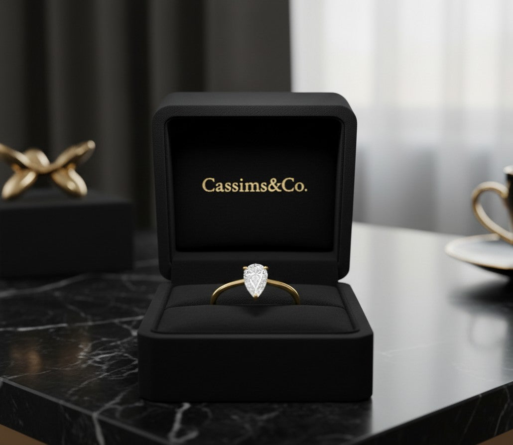 Cassims&Co. 9ct yellow gold engagement ring with a 0.50ct pear-shaped lab grown diamond in a black velvet box.