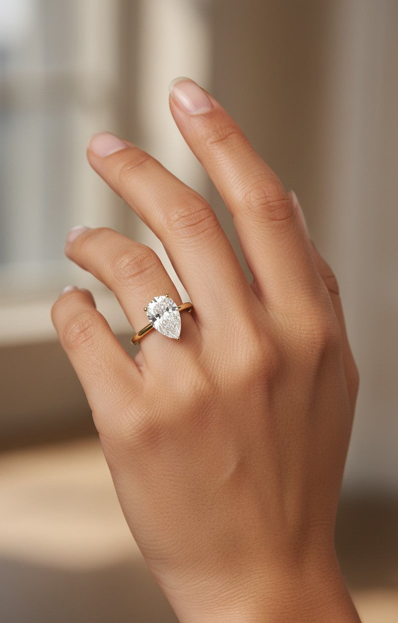 Cassims&Co. 9ct yellow gold engagement ring featuring a 2.00ct pear shape lab grown diamond solitaire on a hand.
