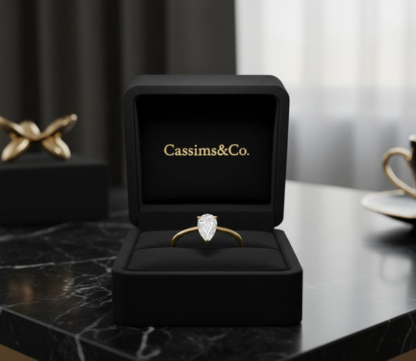Cassims&Co. 9ct yellow gold engagement ring with a 0.50ct pear-shaped lab grown diamond in a black velvet box.