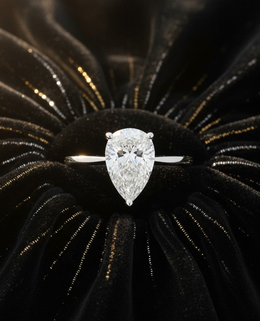 Cassims&Co. 9ct white gold engagement ring featuring a 1.58ct pear-shaped lab grown diamond solitaire on black velvet.
