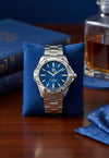Cassims&Co. TAG Heuer Aquaracer watch with a blue sunray dial and stainless steel bracelet on a blue display cushion.