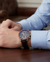 Cassims&Co. TAG Heuer Carrera chronograph watch with brown dial and leather strap worn on a man's wrist