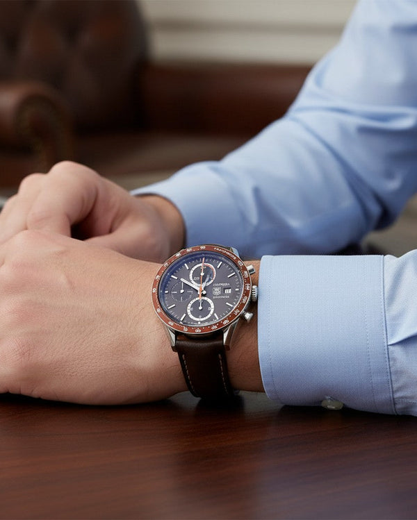Cassims&Co. TAG Heuer Carrera chronograph watch with brown dial and leather strap worn on a man's wrist