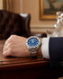 Cassims&Co. pre-owned TAG Heuer Formula 1 watch with a blue dial and stainless steel bracelet worn on a wrist.