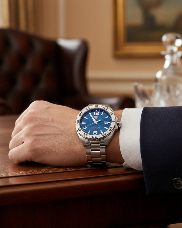 Cassims&Co. pre-owned TAG Heuer Formula 1 watch with a blue dial and stainless steel bracelet worn on a wrist.