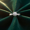 Cassims&Co. 9ct white gold engagement ring featuring a diamond cluster setting and pavé diamond shoulders on green velvet.