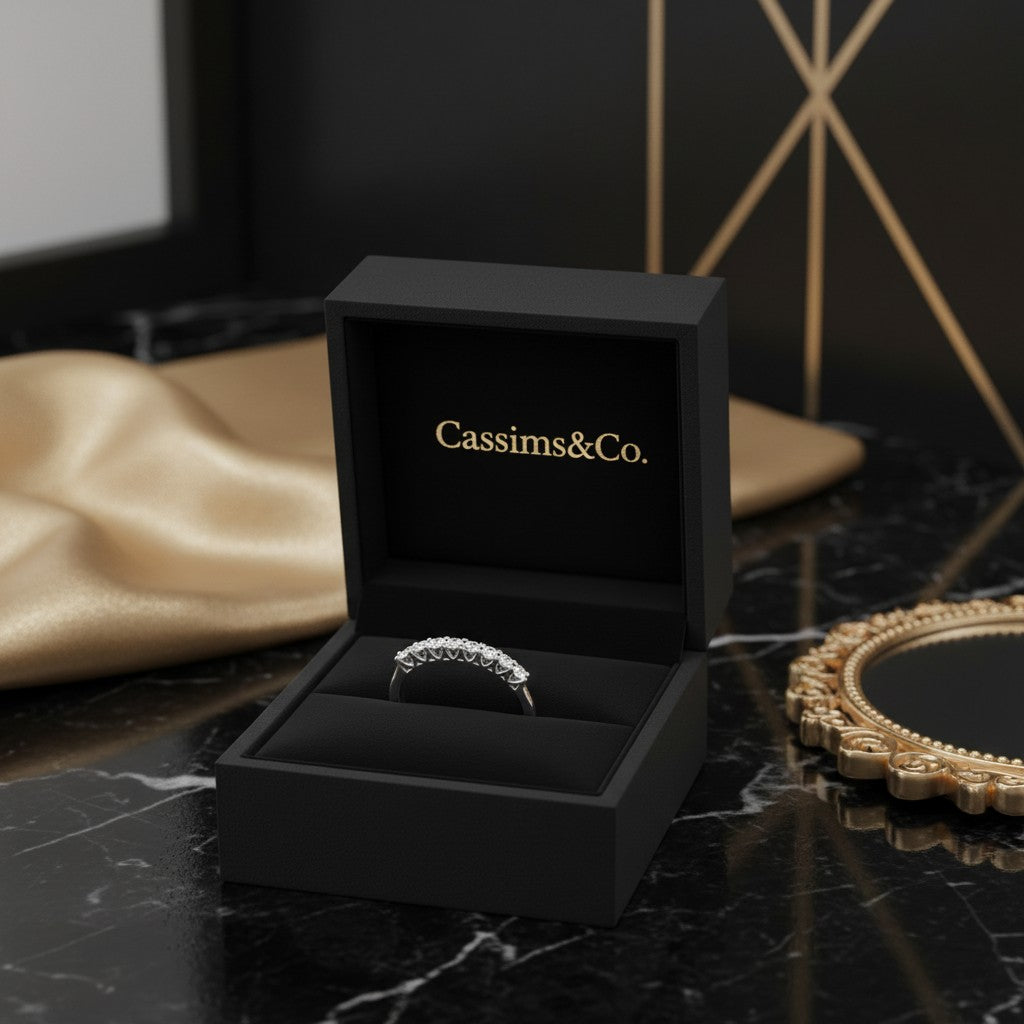 Cassims&Co. 9ct white gold eternity ring with lab grown diamonds in a black velvet presentation box on marble surface.