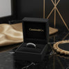 Cassims&Co. 9ct white gold eternity ring with lab grown diamonds in a black velvet presentation box on marble surface.