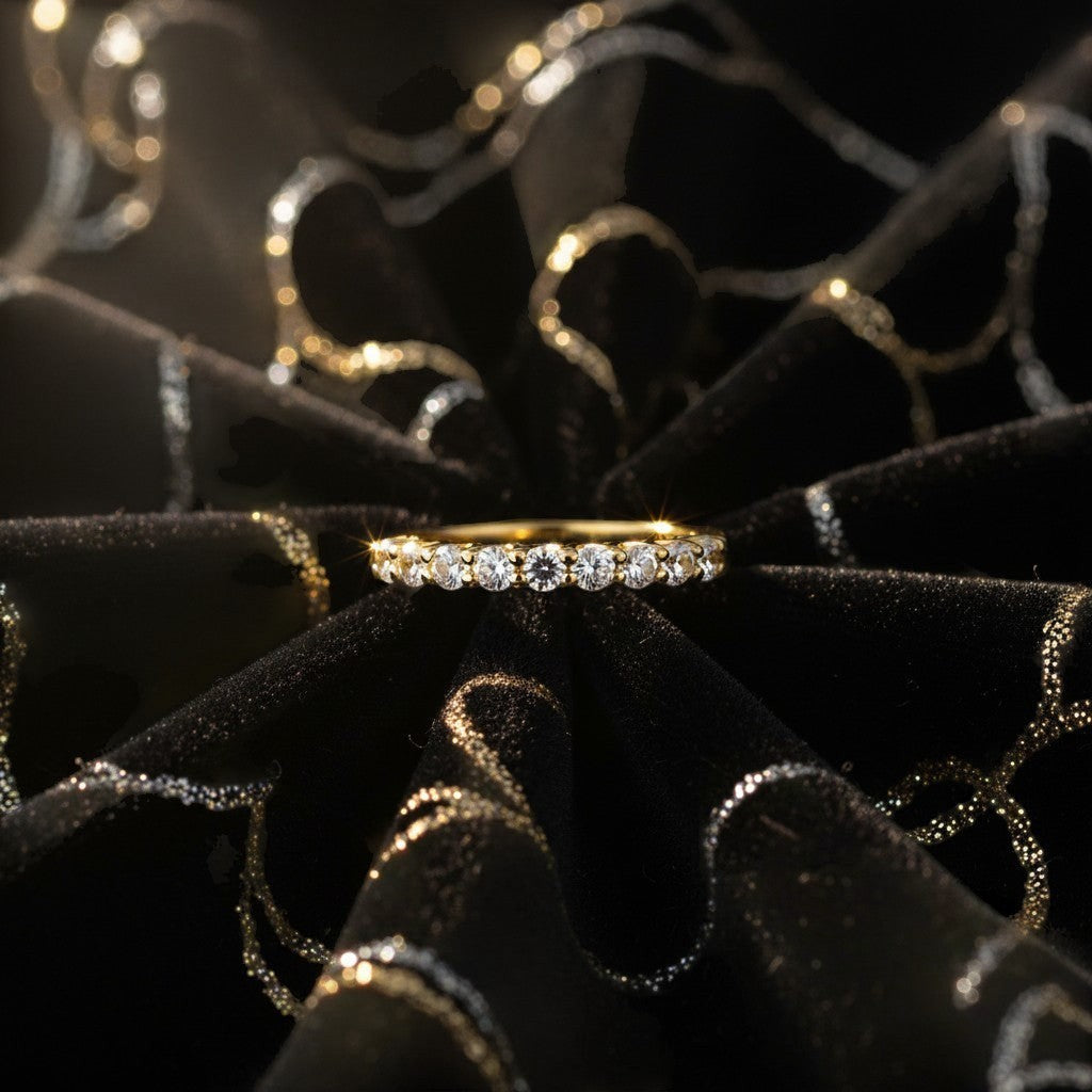 Cassims&Co. 9ct yellow gold eternity ring featuring a row of brilliant lab grown diamonds on black velvet fabric.