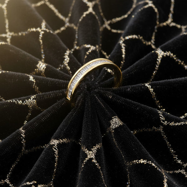Cassims&Co. 9ct yellow gold band featuring a channel-set row of baguette-cut diamonds on black velvet fabric.