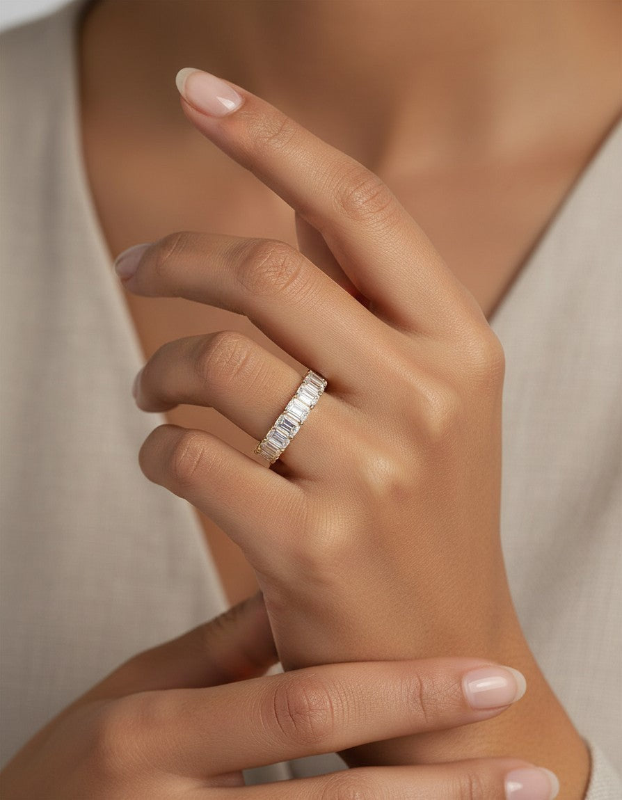Cassims&Co. 9ct yellow gold eternity band featuring emerald cut lab grown diamonds on a woman's finger