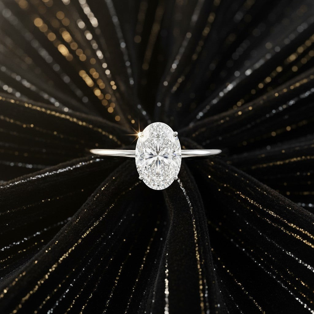 Cassims&Co. 1.00ct oval lab grown diamond solitaire engagement ring in 9ct white gold on a black textured background.