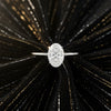Cassims&Co. 1.00ct oval lab grown diamond solitaire engagement ring in 9ct white gold on a black textured background.