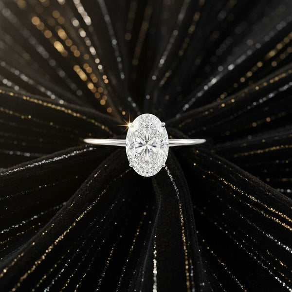 Cassims&Co. 1.00ct oval lab grown diamond solitaire engagement ring in 9ct white gold on a black textured background.