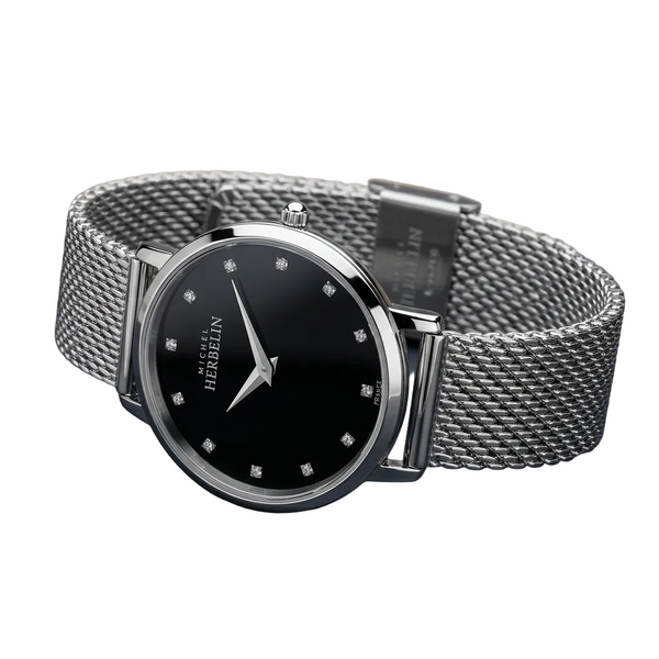 Silver watch with black dial on a dark surface