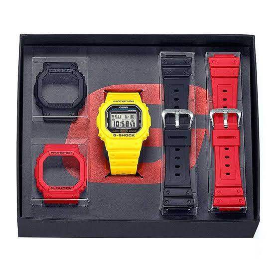 Casio G-Shock DWE-5600R-9D yellow digital watch with interchangeable red and black bezels and straps in presentation box